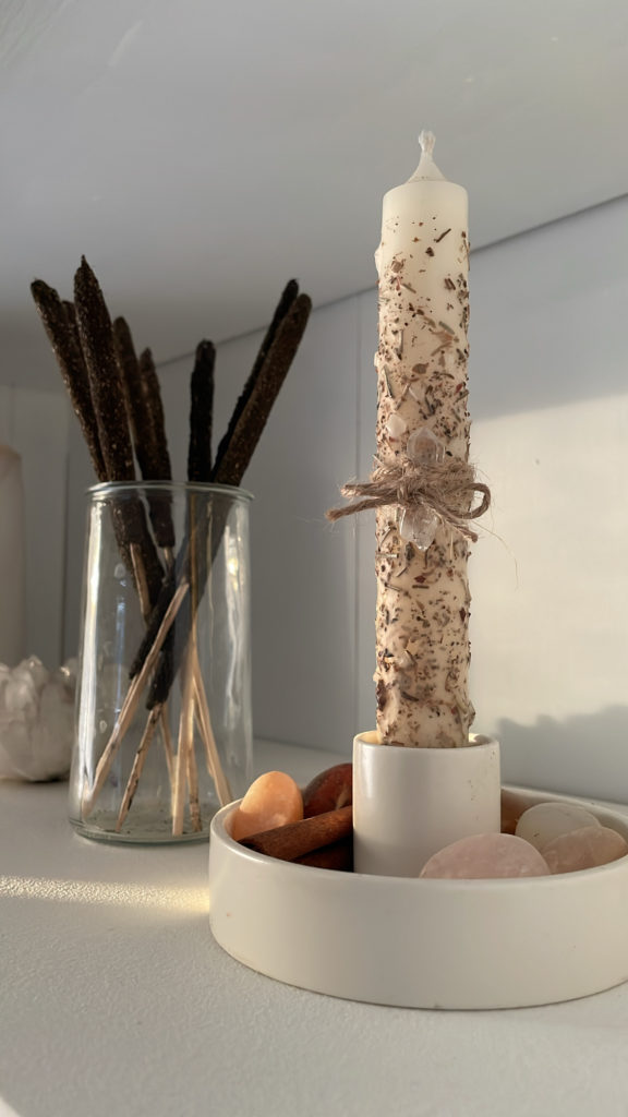 a candle in a holder with a rope tied around it